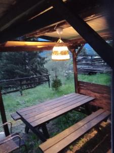 une table de pique-nique sous une pergola avec une lumière dans l'établissement Glamping C Selva Tenda Castagno, à Piano Porlezza 5 autres photos