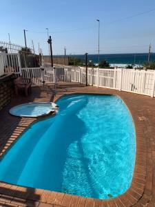 a large blue swimming pool with the ocean in the background at Peacehaven flat 208 in Scottburgh