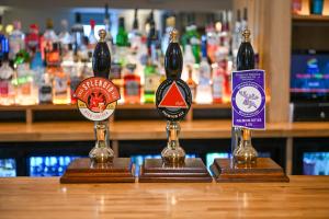 two bottles of beer sitting on top of a bar at Castle Court in Beaumaris
