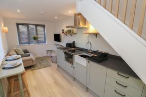 a kitchen with a staircase leading to a living room at The Old Dairy Barn in Penzance