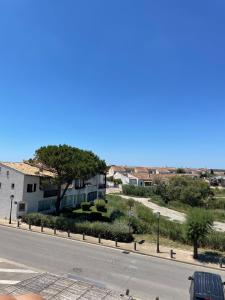 una calle vacía con un edificio al lado de una carretera en Appartement Les Saintes, en Saintes-Maries-de-la-Mer
