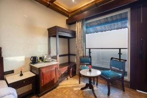 a bedroom with a bed and a table and a window at Jharipani Castle in Mussoorie