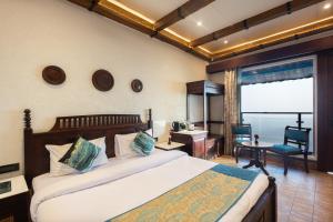 a bedroom with a bed and a desk and a chair at Jharipani Castle in Mussoorie