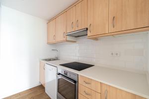cocina con armarios de madera, fregadero y fogones en Apartamento Cánovas Vigo Center, en Vigo 11 fotos más