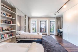 1 dormitorio con 2 camas y estante para libros en Luxury Living in Shkoder Historic Heart, en Shkodër