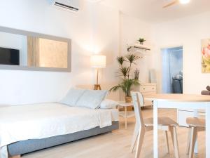 a white bedroom with a bed and a table at ISG Apartments Triana Jacuzzi 1 in Seville +14 photos