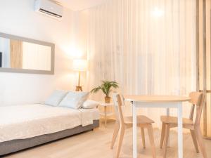 a white bedroom with a bed and a table at ISG Apartments Triana Jacuzzi 1 in Seville