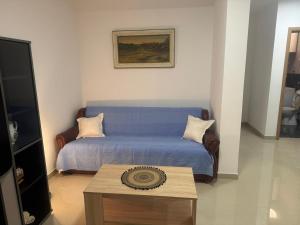 a bedroom with a blue bed and a coffee table at Tara Apartment in Herceg-Novi