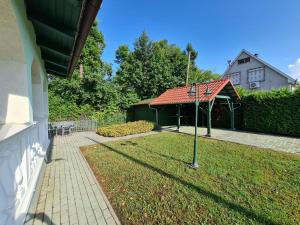 a house with a yard with a pathway and a house at Zöldház in Balatonmáriafürdő