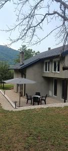 a house with a table and benches in front of it at Apartman Nadja&Dani in Kulen Vakuf