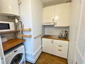 a small kitchen with a washing machine and a microwave at L'authentique - Centre - Calme - Équipé - Basque in Bayonne