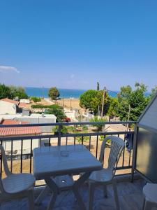 a table and chairs on a balcony with a view of the beach at Golden Beach Sea View in Nea Mesangala
