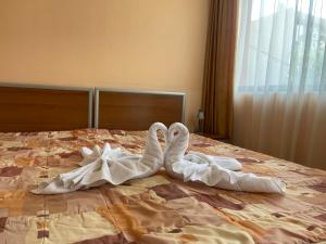 two towel swans laying on top of a bed at Sofia Family Hotel in Pomorie