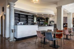 a bar in a restaurant with a table and chairs at Piccolo hotel le Palme in San Bartolomeo al Mare