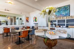 jadalnia ze stołem i wazonem kwiatów w obiekcie Piccolo hotel le Palme w mieście San Bartolomeo al Mare
