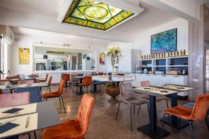 a restaurant with tables and chairs and a stained glass window at Piccolo hotel le Palme in San Bartolomeo al Mare