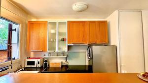 une cuisine avec des armoires en bois et un réfrigérateur en acier inoxydable dans l'établissement Appartement 4 personnes 10 min Disney, à Montévrain