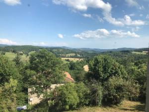 a view of the countryside from a house in the trees at Gîte 10 personnes Ardèche Jacuzzi in Saint-Apollinaire-de-Rias