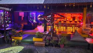 哈林海滩MBAR HOSTEL HAAD RIN的带有植物和灯光的酒吧的夜总会