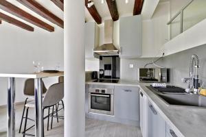 a kitchen with white cabinets and a counter with a sink at Cosy Farm House in Wissous