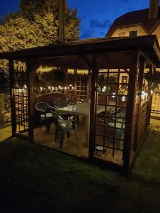 a wooden gazebo with a table and chairs at Pokoje gościnne Edan in Łeba