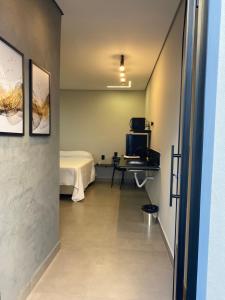 a room with a bed and a table in a room at Loft ARAXÁ in Araxá