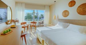 a bedroom with a bed and a dining room with a table at Nissi Beach Resort in Ayia Napa +37 photos