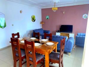 Un comedor con mesa y sillas de madera. en Résidence premium confort autonome, en Douala