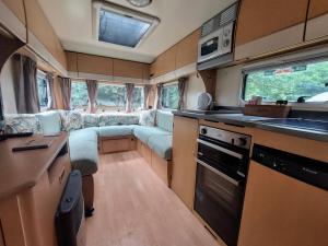 a small kitchen with a couch in the back of an rv at Billie in Hope