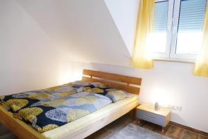 a bedroom with a bed and a window at Ferienwohnungen Brombachsee in Pleinfeld