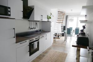 a white kitchen with a sink and a stove at Ferienwohnungen Brombachsee in Pleinfeld +66 photos