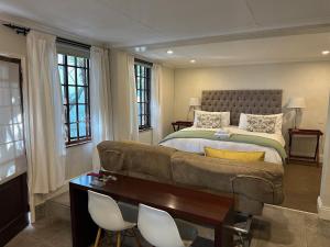 a bedroom with a couch and a bed with windows at Melville Turret Guesthouse in Johannesburg