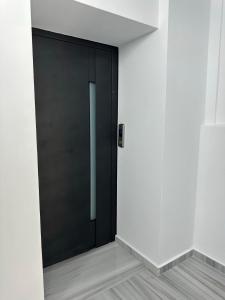 a black door in a room with white walls at Marathon Apartment in Lixouri