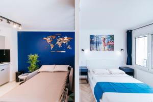una stanza con due letti e una parete blu di Paris Porte de Versailles - ISSYHOST a Issy-les-Moulineaux