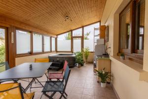 a screened in porch with a table and chairs and a stove at LeSaumurTranquille - Le Poitrineau in Saumur