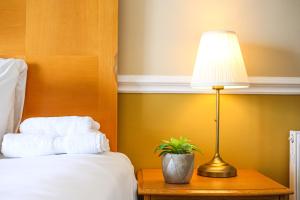 a lamp sitting on a table next to a bed at The Wellington Hotel in Ventnor