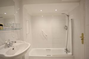 a white bathroom with a sink and a shower at The Wellington Hotel in Ventnor