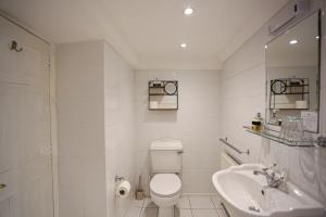 a white bathroom with a toilet and a sink at The Wellington Hotel in Ventnor