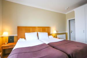 a bedroom with a large bed with a purple blanket at The Wellington Hotel in Ventnor