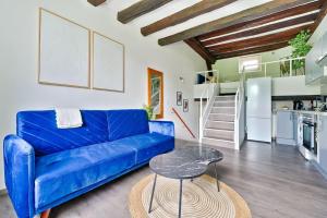 a living room with a blue couch and a table at Welcome to Clara House in Wissous