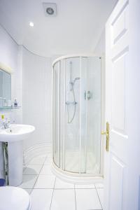 a white bathroom with a shower and a sink at The Wellington Hotel in Ventnor