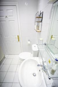 a white bathroom with a sink and a toilet at The Wellington Hotel in Ventnor