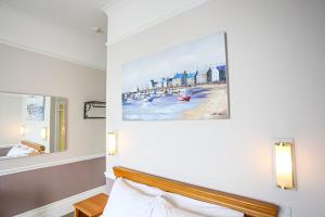 a bedroom with a painting above a bed at The Wellington Hotel in Ventnor