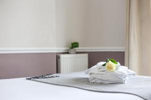 a pile of white towels sitting on a bed at The Wellington Hotel in Ventnor