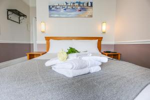 a pile of towels sitting on top of a bed at The Wellington Hotel in Ventnor