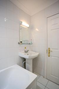 a white bathroom with a sink and a mirror at The Wellington Hotel in Ventnor