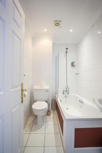 a white bathroom with a toilet and a sink at The Wellington Hotel in Ventnor