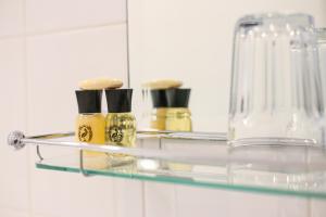 a glass shelf with perfume bottles on it in a bathroom at The Wellington Hotel in Ventnor