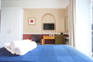 a bedroom with a blue bed with towels on it at The Wellington Hotel in Ventnor