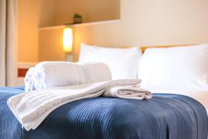 a pile of towels sitting on top of a bed at The Wellington Hotel in Ventnor